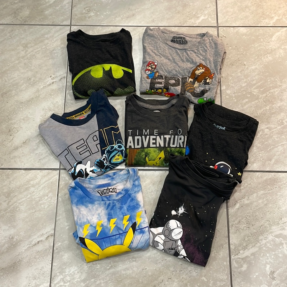 Bundle of 7 t shirts with various graphic designs.